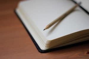 pencil resting on a blank notebook