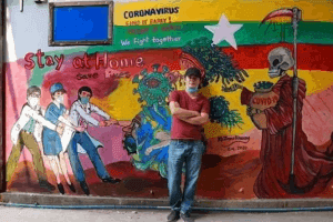artist standing in front of mural