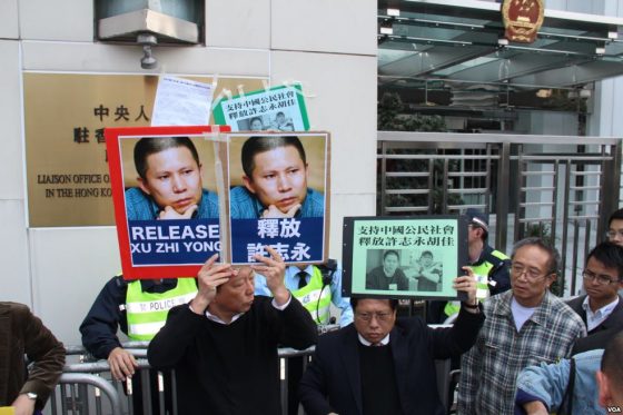 People hold signs in support of Xu Zhiyong’s release from prison