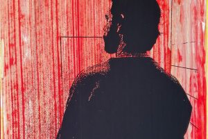 Silhouette of a man facing away from the viewer in a small, empty red room