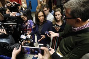 Reporters surrounding Kamala Harris with mics and cell phones