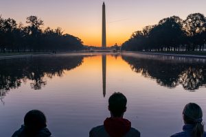 washington monument with three people in foreground