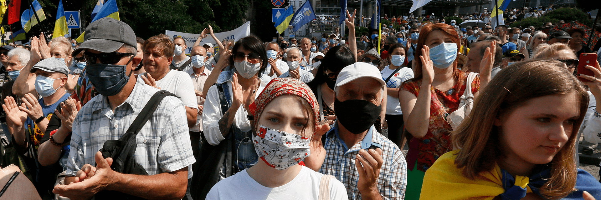 Supporters gathered in front of a court building in Ukraine, many of them clapping and wearing face masks