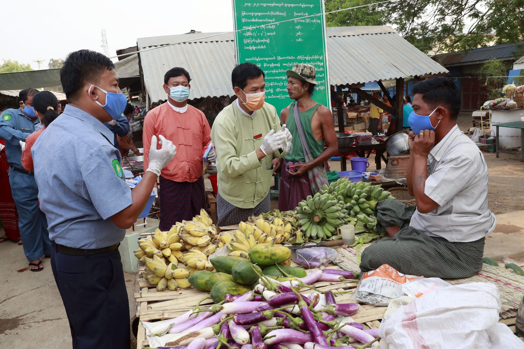 Government officials distribute face masks to vendors in Myanmar
