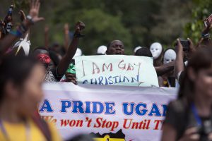 Ugandans holding up signs and raised fists at pride celebrations