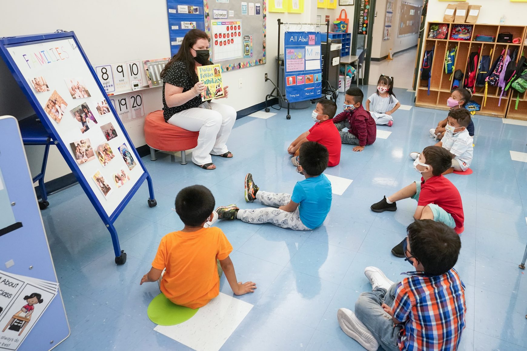 Students gathered around a teacher reading