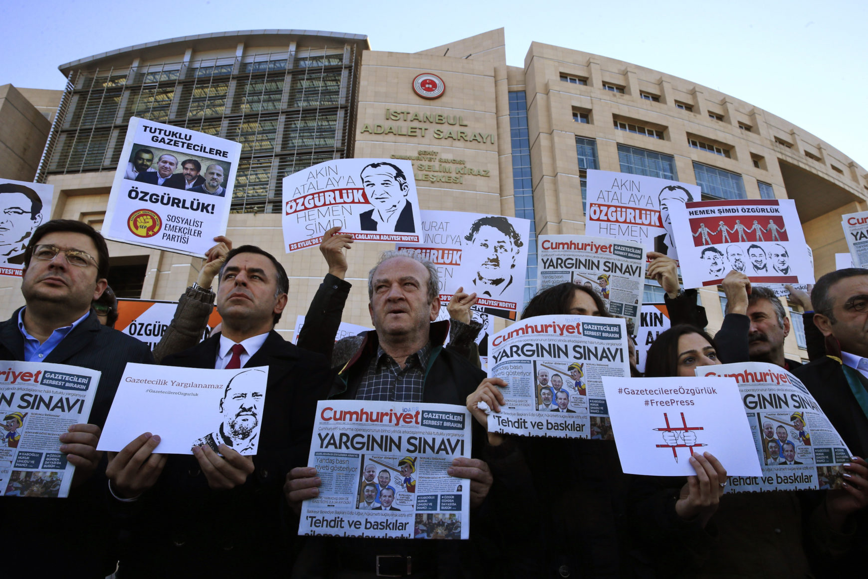 People hold signs in a protest outside a Turkish court house