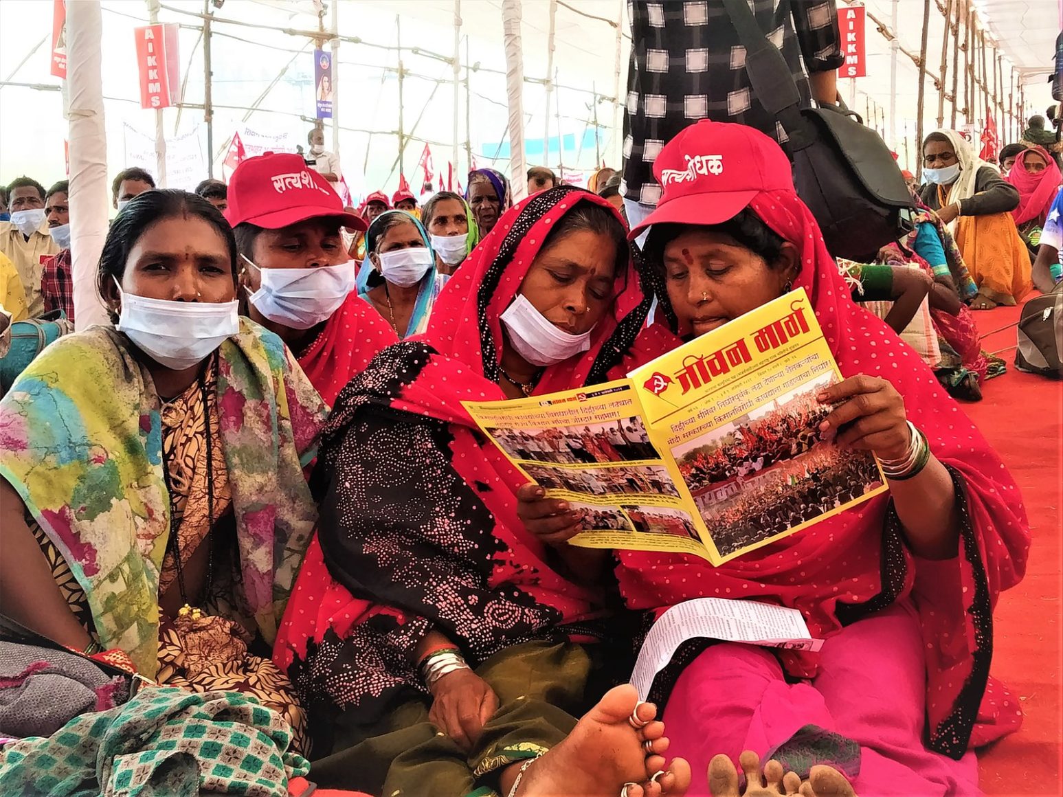 Women reading a magazine at farmers’ protest in January 2021