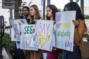 Girls holding a banner that says "Say Gay"