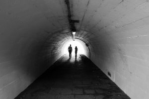 two people walking through a tunnel