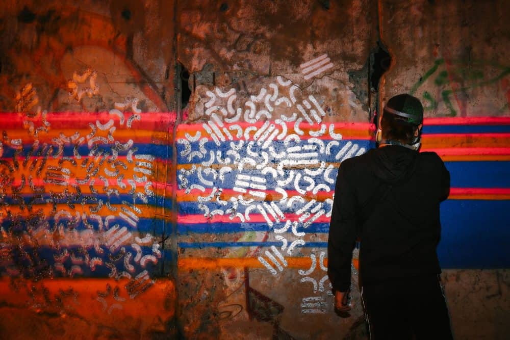 artist HIDEYES spray-painting the Berlin Wall section in Seoul