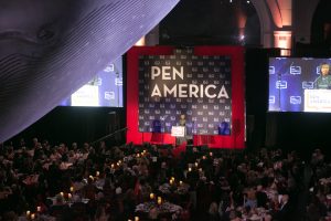 Photo showing Anita Hill on stage, with gala attendees seated at tables