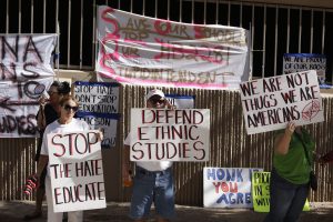 Protesters holding signs about defending ethnic studies