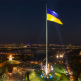 Ukraine flag on a flagpole with skyline in background