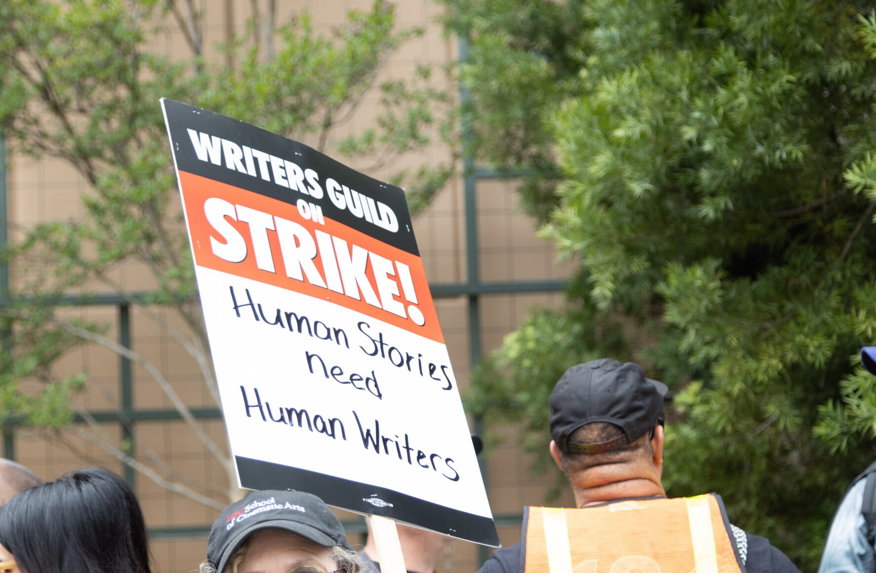 A WGA picket sign that reads "Writers Guild on Strike! Human Stories need Human Writers"