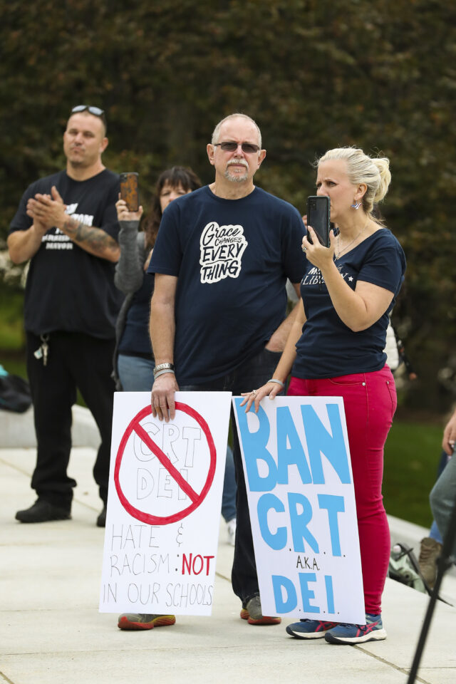 Protesters hold signs at a Moms for Liberty rally at the state Capitol in Harrisburg, Pennsylvania on October 9, 2021. One sign says "BAN CRT and DEI" and one shows "CRT" and "DEI" behind a red cross above text that says "Hate & racism not in our schools." (Photo by Paul Weaver/Sipa USA)(Sipa via AP Images)