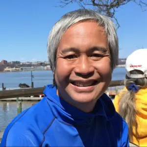 Anick Jesdanun smiling in front of a pier in New York City