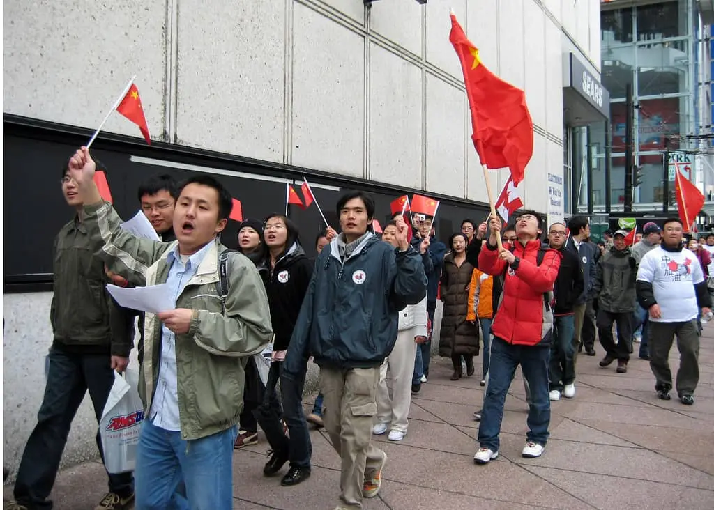 A group of people holding flags, united in celebration, their voices rising in a joyful glossolalia.