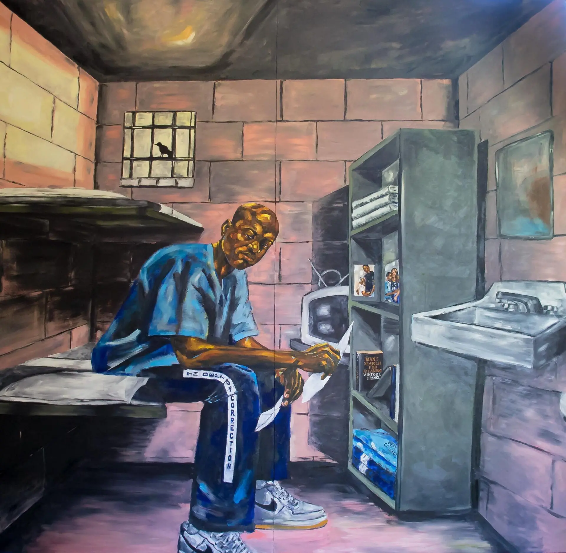 Man sitting on a bunk bed in a prison cell holding pieces of paper in his hands; above him, a black bird perched on the bars of the window