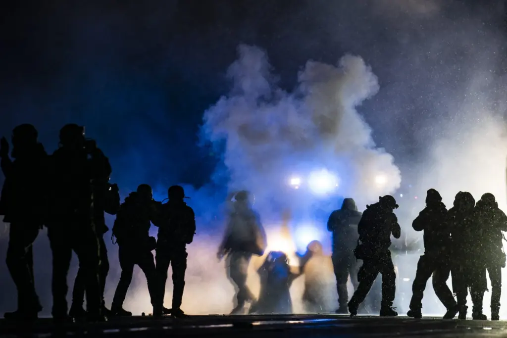 Authorities fire gas munitions at demonstrators gathered late Tuesday, April 13, 2021, outside the Brooklyn Center Police Department to protest the shooting death of Daunte Wright in Brooklyn Center, Minn.