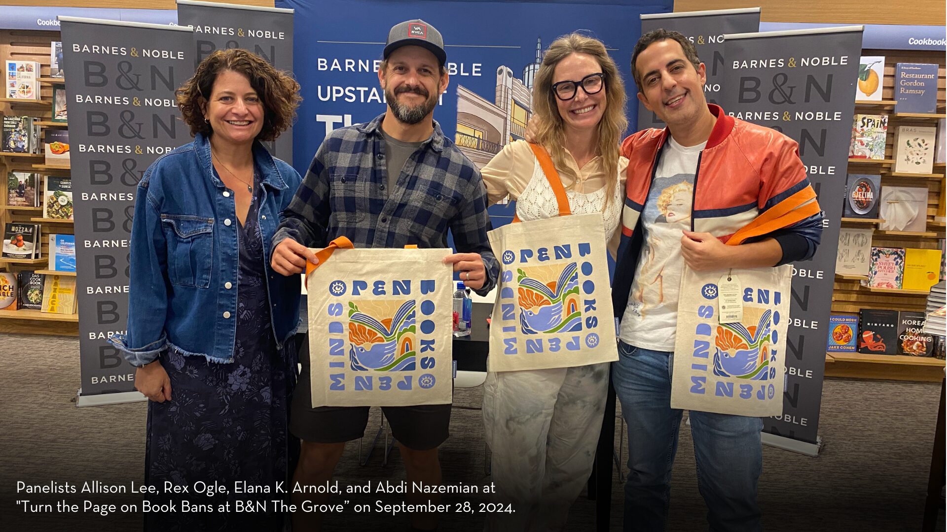 Four people stand smiling in a bookstore, holding tote bags with OPEN MINDS OPEN BOOKS text. Behind them are shelves of books and Barnes & Noble signage. Theyre participating in a panel event for Banned Books Week 2024.