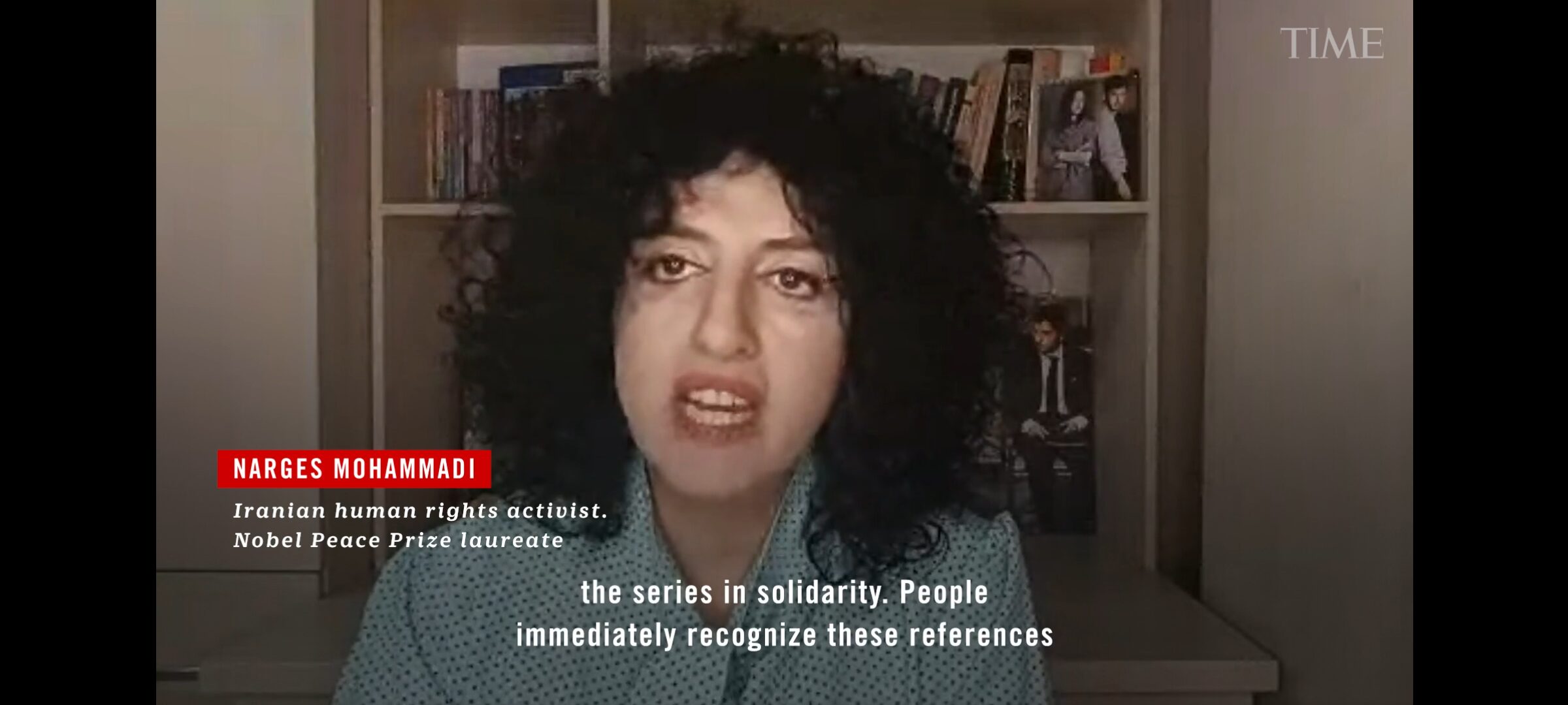A woman with curly black hair sits in front of a bookshelf, speaking. She is identified as Narges Mohammadi, an Iranian human rights activist and Nobel Peace Prize laureate. The text at the bottom is partially visible.