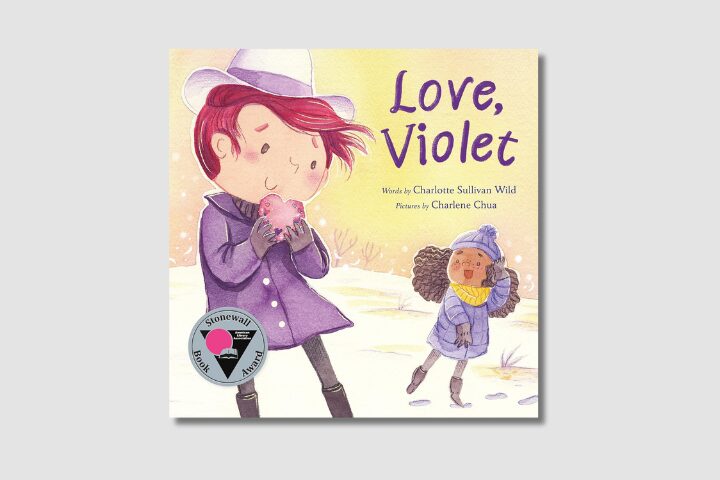 Illustrated book cover for Love, Violet by Charlotte Sullivan Wild, showing a girl in a purple coat and hat holding a heart-shaped card, while another girl in a blue coat and yellow hat stands nearby. A Stonewall Book Award sticker is on the cover.